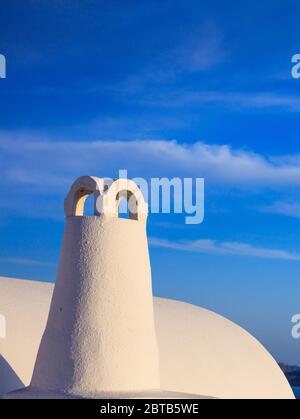 Santorini Insel, Griechenland, Weiß bemalter Schornstein Nahaufnahme auf Caldera.traditionelle architektonische Detail vor blauem Himmel Hintergrund, vertikale Foto Stockfoto