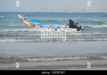 Ein Pirogue (handwerkliches Fischerboot), das sich am Yoff Beach, Dakar, Senegal, der Brandung trotzt Stockfoto