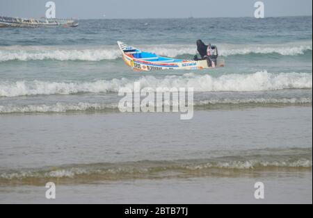 Ein Pirogue (handwerkliches Fischerboot), das sich am Yoff Beach, Dakar, Senegal, der Brandung trotzt Stockfoto