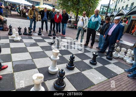 Amsterdam, Niederlande - 9. September 2018: Schachspieler auf einem großen Schachbrett, das auf dem Straßenboden in Amsterdam, Niederlande, gebaut wurde Stockfoto