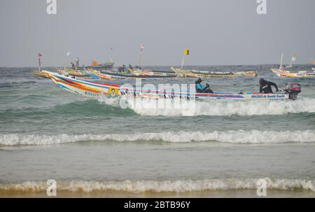 Ein Pirogue (handwerkliches Fischerboot), das sich am Yoff Beach, Dakar, Senegal, der Brandung trotzt Stockfoto