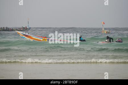 Ein Pirogue (handwerkliches Fischerboot), das sich am Yoff Beach, Dakar, Senegal, der Brandung trotzt Stockfoto