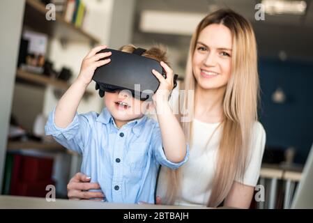 Mutter mit Kind studiert Brille mit virtueller Realität Stockfoto