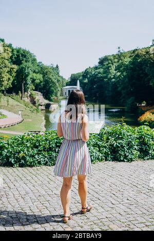 Sofia Park, Uman. Junge Frau in einem Kleid mit einer touristischen Karte. Mädchen Tourist mit einer touristischen Karte im Sommerpark. Stockfoto