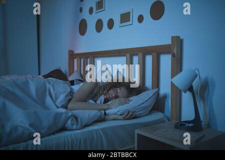 Porträt von lockig behaarten jungen Frau schlafen ruhig in einem komfortablen Bett in der Nacht, kopieren Raum Stockfoto
