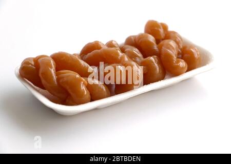 Traditionelle südafrikanische klebrige Koekschwestern isoliert auf weiß in einem Polystyrol-Tablett Stockfoto