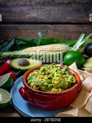 Guacamole Sauce mit geröstetem Mais und Rohzutaten Stockfoto