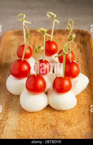 Essen Snacks und Vorspeisen am Buffet. Canapés mit Mozzarella-Käse und Kirschtomaten auf Holztablett serviert Stockfoto