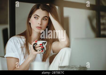 Portrait der jungen schönen Frau mit Becher in der Hand. Stockfoto