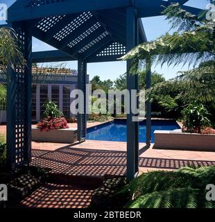 Blick durch ein rankgitter Gazebo eines blauen Pool Stockfoto
