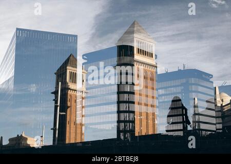 Zwei Türme in Spanien Platz in Barcelona und ein kleines Mädchen tanzen neben ihnen und eine Doppelbelichtung Komposition mit einigen modernen Gebäuden Stockfoto