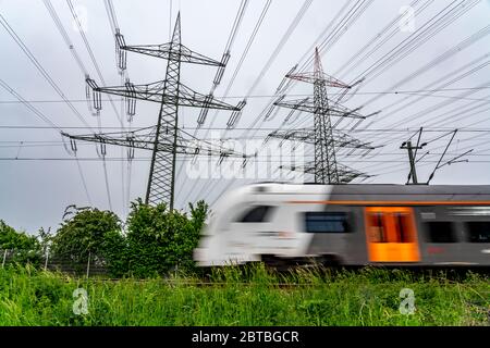 Zug auf der Strecke Essen-Bochum, Stromleitungen, Hochspannungs-Netz, 380 Kilovolt, transportiert Strom aus Großkraftwerk Stockfoto