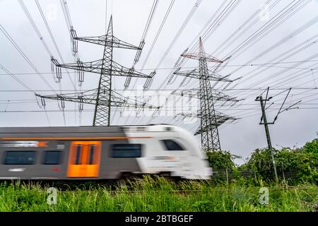 Zug auf der Strecke Essen-Bochum, Stromleitungen, Hochspannungs-Netz, 380 Kilovolt, transportiert Strom aus Großkraftwerk Stockfoto