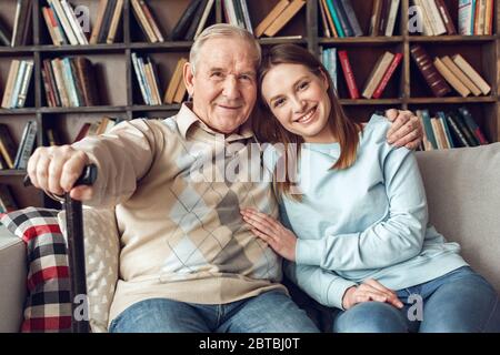 Vater und Tochter zu Hause Bibliothek sitzen umarmt lächelnd fröhlich Stockfoto