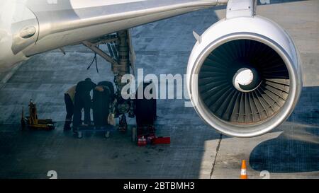 Foto von der Bodencrew, die das Flugzeugrahmen vor dem Flug überprüft Stockfoto