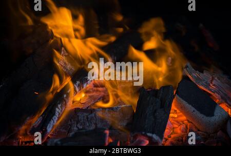 Gelber und orangefarbener Feuerball, der den schwarzen Hintergrund aufheizt. Stockfoto