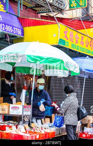 New York City - 24. Mai 2020: Blick auf die Menschen auf den Bürgersteigen in Chinatown in Manhattan, während der Covid-19 Coronavirus Pandemie Stockfoto