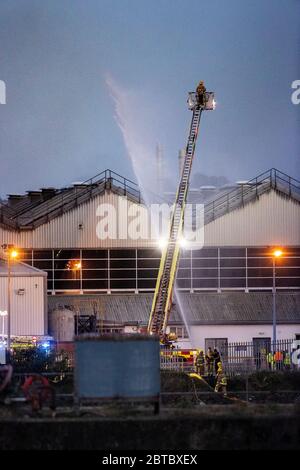 Mitglieder des NIFRS Northern Ireland Fire and Rescue Service nehmen an diesem Abend bei einem Brand in Bombardier Aerospace in Belfasts Hafengebiet Teil. Stockfoto