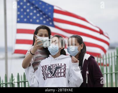 Rye, Usa. Mai 2020. Kinder machen ein Selfie in der Nähe einer amerikanischen Flagge für das Memorial Day Wochenende am Rye Playland Beach während der Coronavirus Pandemie in New York City am Sonntag, den 24. Mai 2020. Weltweit wurden mehr als 5.3 Millionen Fälle von COVID-19 gemeldet, die zu über 343,000 Todesfällen geführt haben. Foto von John Angelillo/UPI Quelle: UPI/Alamy Live News Stockfoto