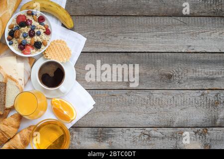 Gesundes Frühstück mit Müsli, Früchte, Beeren, Nüsse, Kaffee, Eier, Honig, Hafer und anderen Nahaufnahme Stockfoto