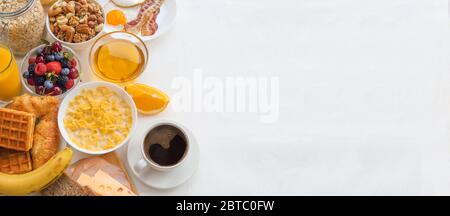 Gesundes Frühstück mit Müsli, Früchte, Beeren, Nüsse, Kaffee, Eier, Honig, Hafer und anderen auf weißem Hintergrund. Flach, Ansicht von oben, Raum fo kopieren Stockfoto