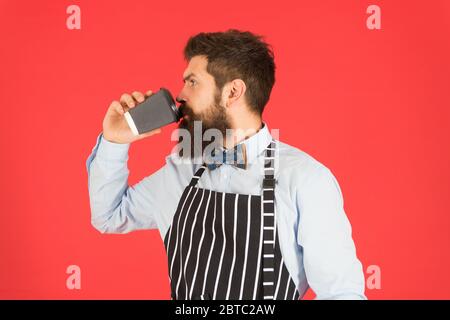 Mehr Kaffee. Ernst Barista trinken großen Latte. Professionelle Kellner oder Barkeeper servieren Kaffee. Brutal Kaffeemaschine. Porträt von bärtigen Barista stehen im Café. Barista gutaussehende Arbeiter. Stockfoto