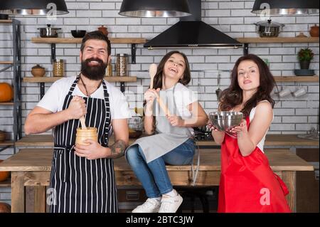 Familie Zeit. Kleines Mädchen mit Mama und Papa in der Küche. Tun Sie alles zusammen. Kochen nach Rezept. Vatertag. Verwandte Spaß beim Kochen. Mutter und Vater lehren Tochter, wie man kocht. Stockfoto