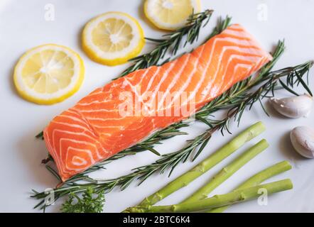 Rohes frisches Lachsfilet mit Kräutern und Zutaten, in weißer Form Stockfoto