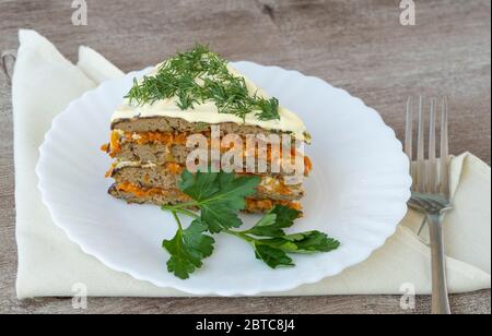 Leberkuchen in einem Teller auf einem Holztisch. Snack aus Leberpfannkuchen und Gemüse Stockfoto