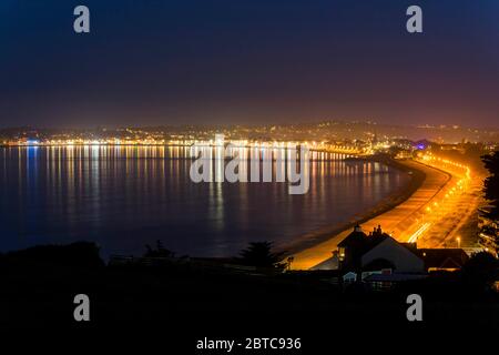 Weymouth, Dorset, Großbritannien. Mai 2020. UK Wetter: Die Lichter von Weymouth in Dorset spiegeln sich im ruhigen Meer, wenn die Nacht einbricht. Bild: Graham Hunt/Alamy Live News Stockfoto