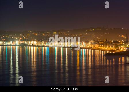 Weymouth, Dorset, Großbritannien. Mai 2020. UK Wetter: Die Lichter von Weymouth in Dorset spiegeln sich im ruhigen Meer, wenn die Nacht einbricht. Bild: Graham Hunt/Alamy Live News Stockfoto