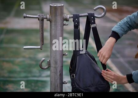 Der Rucksack hängt am Metallspanner für Volleyballnetz Stockfoto