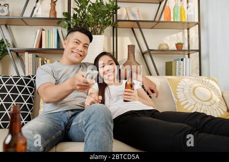 Entspannt faul junge asiatische Paar genießen Fernsehen zu Hause am Freitagabend Stockfoto