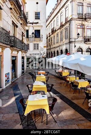 Cafétische mit gelb karierten Tischdecken in Praca Oito de Maio in Coimbra, Portugal Stockfoto