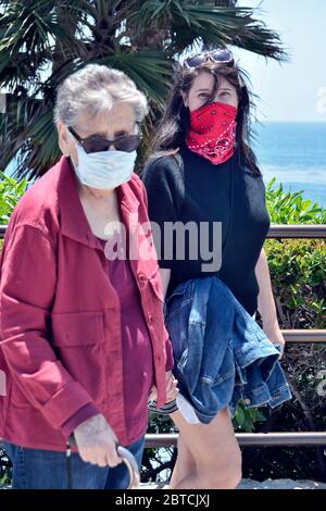 Eine Frau und ihre Mutter in Masken, auf einem Spaziergang Laguna Beach, Kalifornien, USA Stockfoto