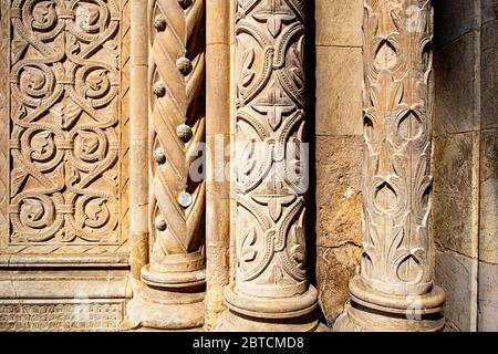 Die Säulen der Kathedrale SE Velha in Coimbra, Portugal, sind mit kunstvoll geschnitzten botanischen Motiven verziert. Stockfoto