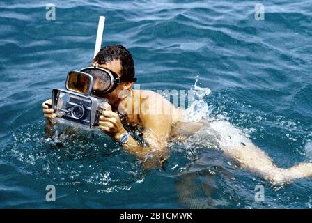 (1962) - - - Astronaut L. Gordon Cooper Jr. beteiligt sich an Quecksilber Wasser egress Training. Er trägt einen Schnorchel und Halten einer Kamera für die Unterwasserfotografie. Stockfoto