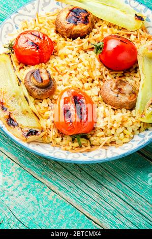 Pilaf, ein Gericht der orientalischen Küche.Türkischer Pilaf mit gegrilltem Gemüse Stockfoto