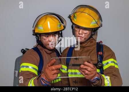 Asiatischer Mann und Frau Feuerwehrmann Porträt, junge lächelnde Feuerwehrmann in Uniform 520 Stockfoto