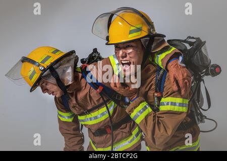 Asiatischer Mann und Frau Feuerwehrmann Porträt, junge lächelnde Feuerwehrmann in Uniform 504 Stockfoto