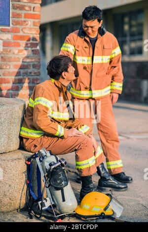 Asiatischer Mann und Frau Feuerwehrmann Porträt, junge lächelnde Feuerwehrmann in Uniform 382 Stockfoto