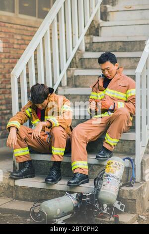 Asiatischer Mann und Frau Feuerwehrmann Porträt, junge lächelnde Feuerwehrmann in Uniform 341 Stockfoto