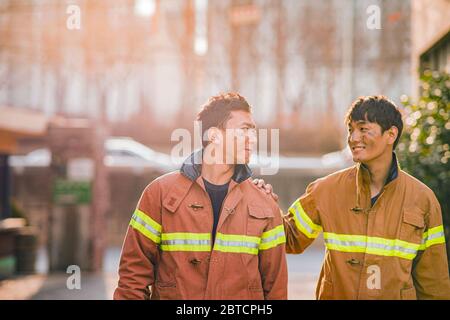 Asiatischer Mann und Frau Feuerwehrmann Porträt, junge lächelnde Feuerwehrmann in Uniform 343 Stockfoto