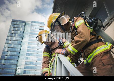 Asiatischer Mann und Frau Feuerwehrmann Porträt, junge lächelnde Feuerwehrmann in Uniform 309 Stockfoto