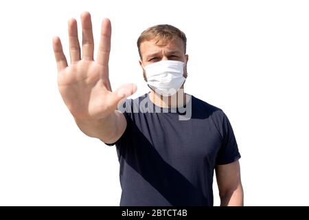 Portrait des kaukasischen weißen Mannes, tausendjährig, in medizinischer Gesichtsmaske mit Stopphandsignal auf weiß isoliert. Coronavirus Welt Pandemie Konzept der s Stockfoto