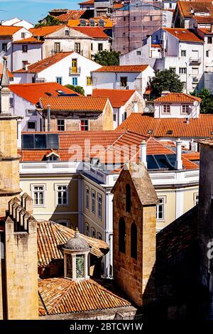 Ein Wirrwarr alter Gebäude in Coimbra, Portugal, mit dem Glockenturm der Kathedrale von SE Velha im Vordergrund. Stockfoto