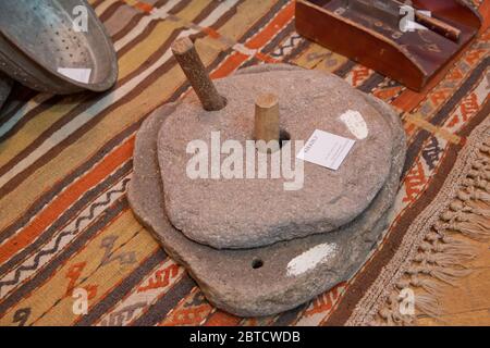 Rotary discoid Mill Stone für Hand- Schleifen einer Getreide zu Mehl. Mittelalterliche hand-driven Mühlstein mahlen Weizen. Die alten Quern Stein Hand Mühle mit Stockfoto