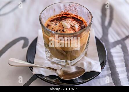 Affogato Coffee: Ein Schuss heißen Espresso, der in einem Glas mit Kakaopulver auf Vanilleeis gegossen wird, wird in einem Restaurant in Singapur serviert Stockfoto