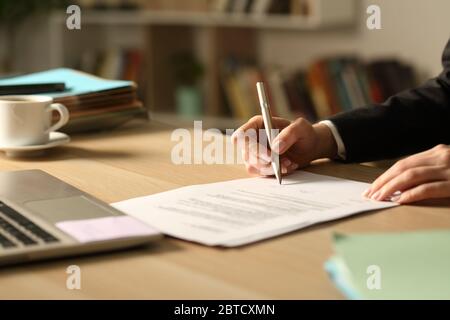 Nahaufnahme der Unternehmerin Hände Unterzeichnung Vertrag in der Nacht zu Hause Stockfoto