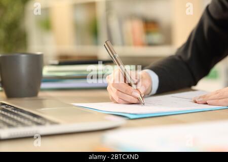 Nahaufnahme der freiberuflichen Frau Hände Ausfüllen Formular Dokument sitzen auf einem Schreibtisch im Homeoffice Stockfoto